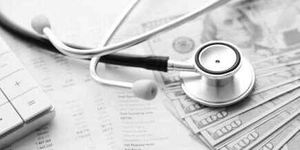 Stethoscope, calculator and money cash on medical data. Concept of health care costs or medical insurance